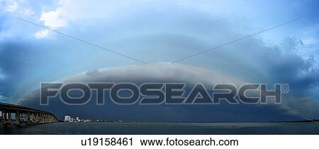 Stock Image - A storm with a shelf cloud moves eastward over the Indian River Lagoon from Cocoa, Florida, USA. Fotosearch