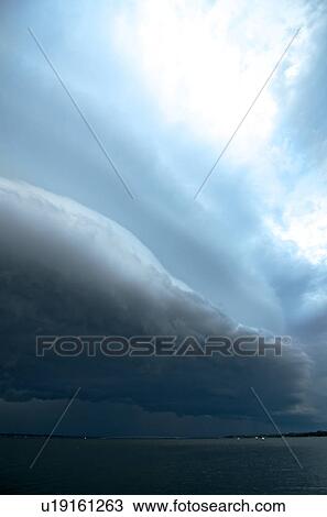 Stock Image - A storm with a shelf cloud moves eastward over the Indian River Lagoon from Cocoa, Florida, USA. Fotosearch