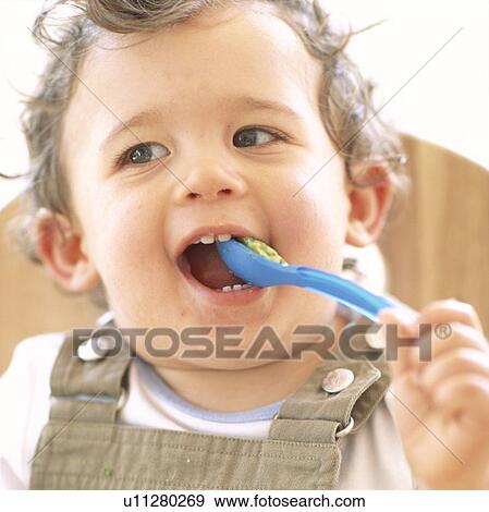 Stock Photo - Baby boy eating. Fotosearch