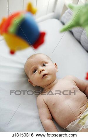 Baby boy in his cot View Large Photo Image Stock Photograph - Baby boy in his cot. Fotosearch