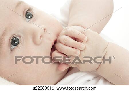 Stock Photography - Baby sucking on his hands. Fotosearch