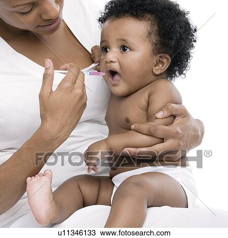 Baby taking medicine View Large Photo Image Stock Image - Baby taking medicine. Fotosearch