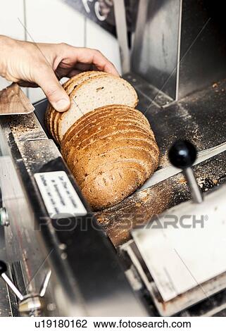 Stock Image - Baker with loaf of sliced bread. Fotosearch