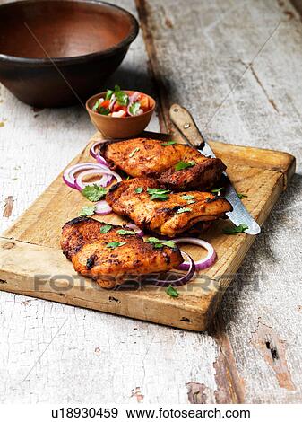 Barbecued tandoori chicken thighs with salad on chopping board View Large Photo Image Stock Photo - Barbecued tandoori chicken thighs with salad on chopping board. Fotosearch