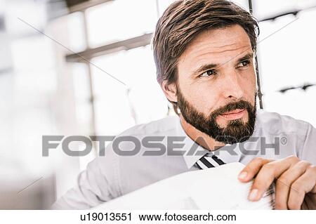 Bearded businessman with paperwork looking away View Large Photo Image Stock Image - Bearded businessman with paperwork looking away. Fotosearch