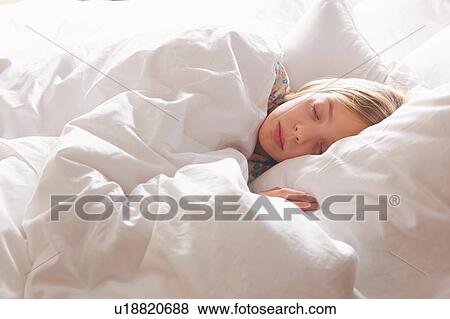 Stock Photo - Blond haired girl asleep in bed. Fotosearch