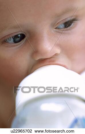 Stock Image - Bottle-feeding baby girl. Fotosearch