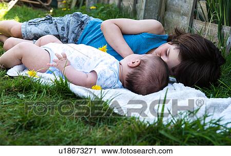 Boy and baby brother gazing at each other in garden View Large Photo Image Stock Image - Boy and baby brother gazing at each other in garden. Fotosearch