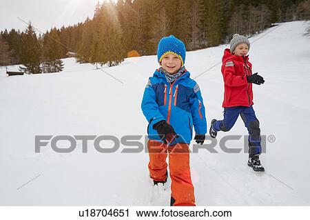 Boy and brother running in snow covered landscape, Elmau, Bavaria, Germany View Large Photo Image Stock Image - Boy and brother running in snow covered landscape, Elmau, Bavaria, Germany. Fotosearch