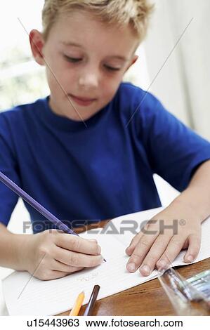 Boy drawing in an exercise book View Large Photo Image Stock Image - Boy drawing in an exercise book. Fotosearch