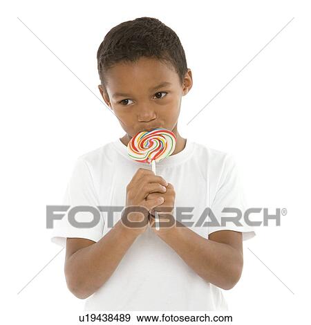 Boy eating a lollipop View Large Photo Image Stock Photo - Boy eating a lollipop. Fotosearch