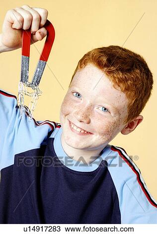 Boy lifting paperclips with a magnet View Large Photo Image Stock Image - Boy lifting paperclips with a magnet. Fotosearch