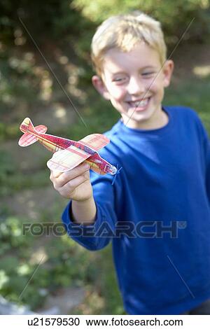 Stock Image - Boy playing with a toy aeroplane. Fotosearch