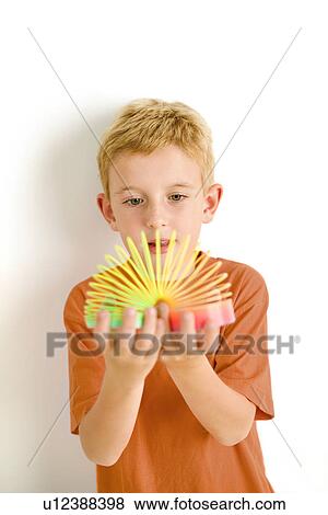Stock Photo - Boy playing with coiled toy. Fotosearch