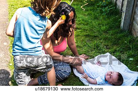Boy playing with mother and baby brother in garden View Large Photo Image Stock Image - Boy playing with mother and baby brother in garden. Fotosearch