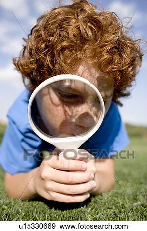 Stock Photo - Boy using a magnifying glass. Fotosearch