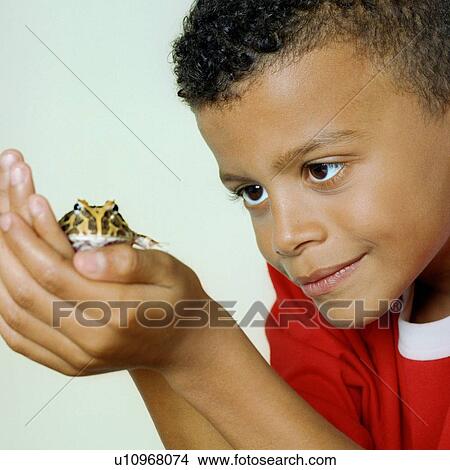 Picture - Boy with his pet toad. Fotosearch