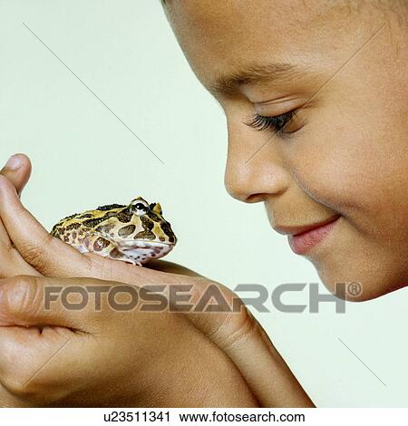 Stock Image - Boy with his pet toad. Fotosearch