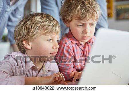 Stock Image - Boys using laptop. Fotosearch