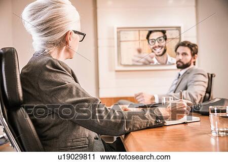 Business people in boardroom having video call meeting View Large Photo Image Stock Image - Business people in boardroom having video call meeting. Fotosearch