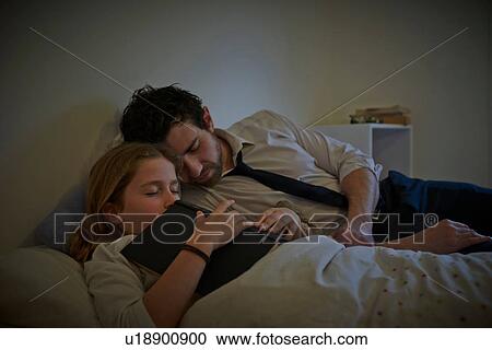 Businessman and daughter with storybook sleeping on bed View Large Photo Image Stock Image - Businessman and daughter with storybook sleeping on bed. Fotosearch