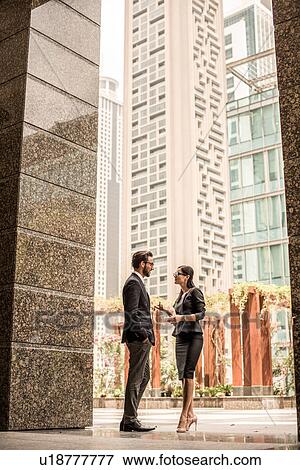 Businessman and woman talking outside office, Dubai, United Arab Emirates View Large Photo Image Stock Photo - Businessman and woman talking outside office, Dubai, United Arab Emirates. Fotosearch