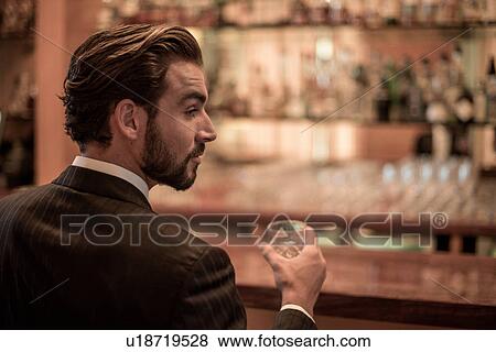 Businessman drinking spirits at hotel bar View Large Photo Image Stock Photo - Businessman drinking spirits at hotel bar. Fotosearch