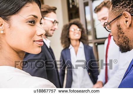 Stock Photo - Businessmen and businesswomen meeting outside office. Fotosearch