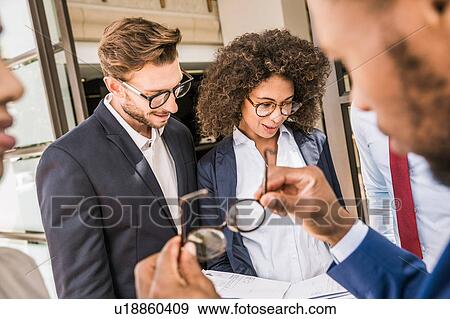 Businessmen and businesswomen preparing paperwork outside office View Large Photo Image Stock Photo - Businessmen and businesswomen preparing paperwork outside office. Fotosearch