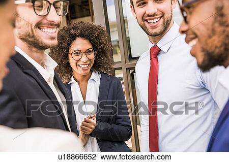 Stock Image - Businessmen and businesswomen talking outside office. Fotosearch