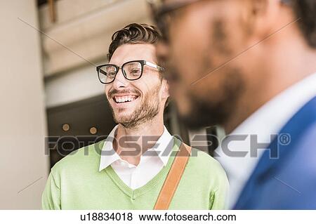 Stock Photo - Businessmen having discussion outside office building. Fotosearch