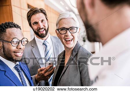 Stock Image - Businesspeople standing in group smiling. Fotosearch