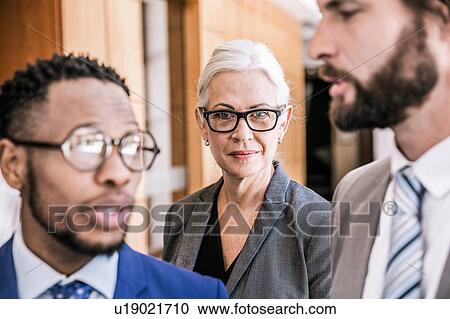 Businesspeople standing in group smiling View Large Photo Image Stock Image - Businesspeople standing in group smiling. Fotosearch