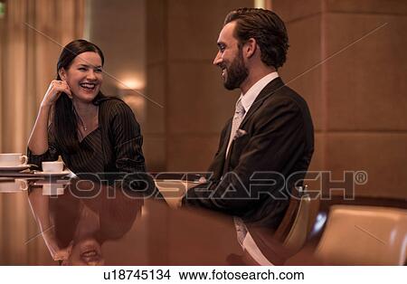 Picture - Businesswoman and man flirting at hotel bar. Fotosearch