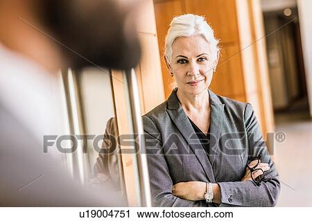 Businesswoman arms crossed looking at camera smiling View Large Photo Image Stock Image - Businesswoman arms crossed looking at camera smiling. Fotosearch