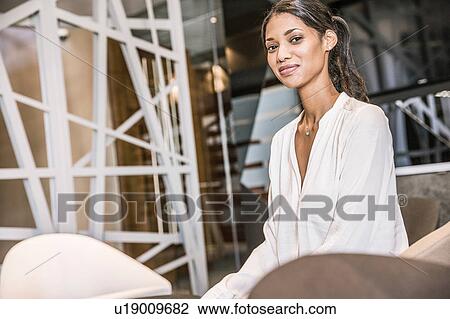 Stock Image - Businesswoman looking at camera smiling. Fotosearch