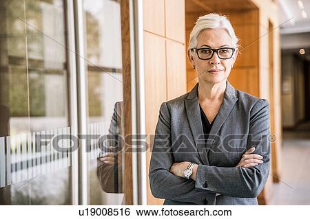 Businesswoman wearing glasses arms crossed looking at camera View Large Photo Image Stock Photograph - Businesswoman wearing glasses arms crossed looking at camera. Fotosearch