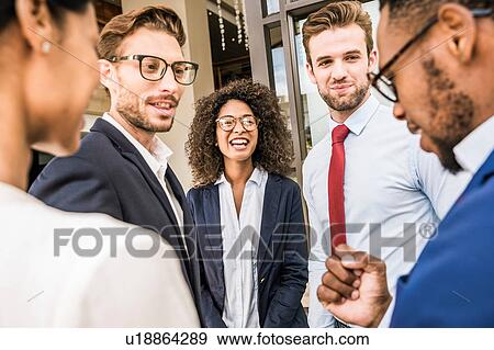 Stock Photo - Businesswomen and businessmen talking outside office. Fotosearch