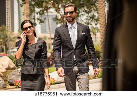 Car window view of businesswoman and man talking on smartphone outside hotel, Dubai, United Arab Emirates View Large Photo Image Stock Image - Car window view of businesswoman and man talking on smartphone outside hotel, Dubai, United Arab Emirates. Fotosearch
