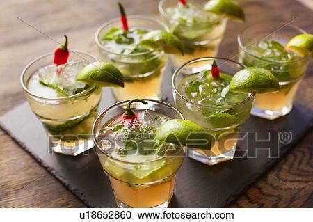 Stock Image - Chilli vodka cocktail garnished with lime wedges. Fotosearch