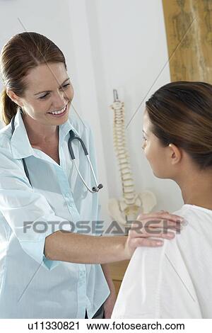 Stock Image - Chiropractor and patient. Fotosearch