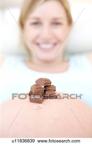Chocolate on a pregnant woman's abdomen View Large Photo Image Stock Photo - Chocolate on a pregnant woman's abdomen. Fotosearch