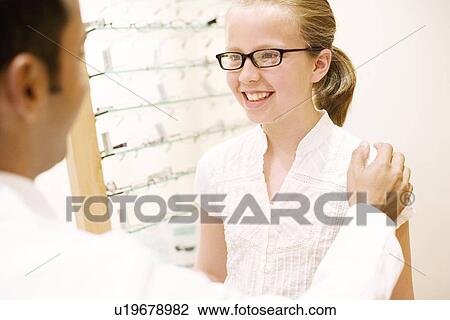 Stock Image - Choosing a pair of glasses. Fotosearch