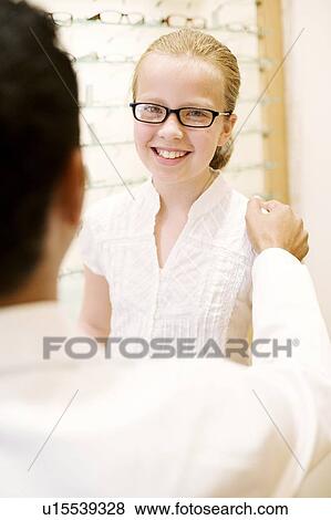 Stock Photo - Choosing a pair of glasses. Fotosearch