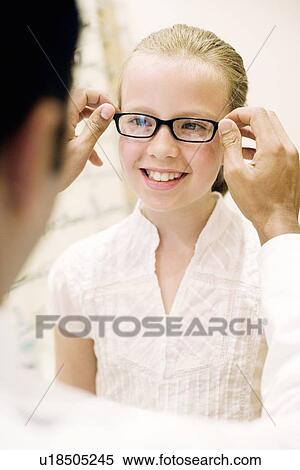 Stock Photography - Choosing a pair of glasses. Fotosearch