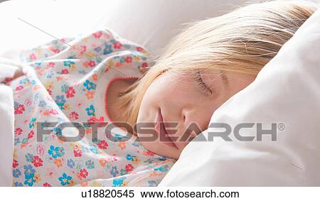Stock Photography - Close up of blond haired girl asleep on pillow. Fotosearch