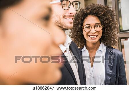 Stock Photo - Close up of businesswomen and businessman outside office. Fotosearch