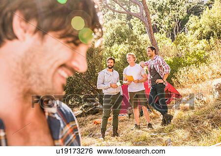 Stock Photograph - Close up of man camping with friends in forest, Deer Park, Cape Town, South Africa. Fotosearch