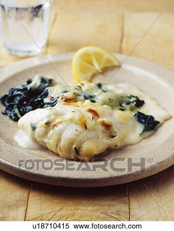 Stock Photography - Cod in cream sauce with spinach and lemon slice. Fotosearch