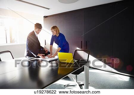 Colleagues in conference room discussing paperwork View Large Photo Image Stock Image - Colleagues in conference room discussing paperwork. Fotosearch